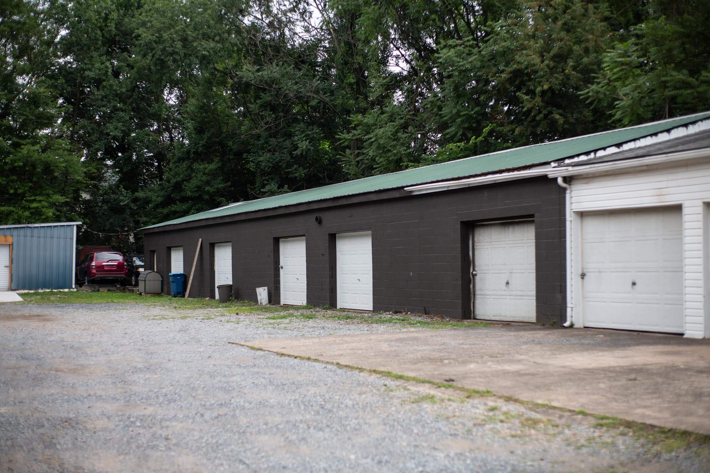 Row of older gray storage doors with peeling paint, highlighting a newly acquired property in Central PA.