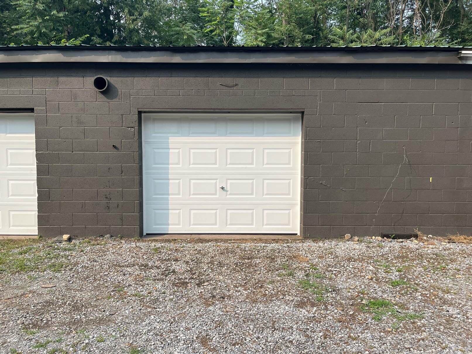 Close-up of gray-painted storage unit doors with numbered signs, part of a recent purchase by Wheaten Investments.